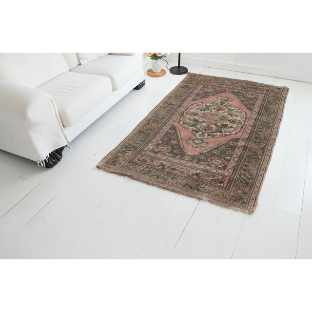 This is a vintage Turkish Oushak rug from the Mid 20th Century. The piece was hand-knotted.