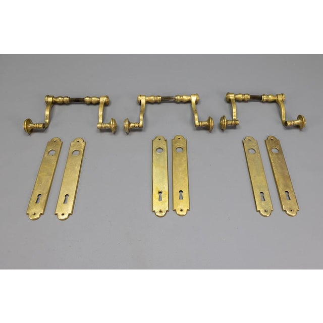 Elegant Set of Three Pairs of French Art Deco Brass Door Handles with Backplates, circa 1930s A beautifully preserved set...