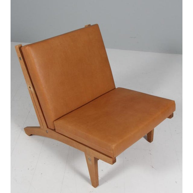 Hans j. Wegner lounge chair with loose cushions new upholstered with vintage tan full grain aniline leather. Frame of...