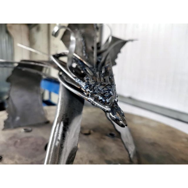 Star Bird Playing with Her Shape unfolds as a luminous paradox: a creature born from raw industrial iron yet animated by a...