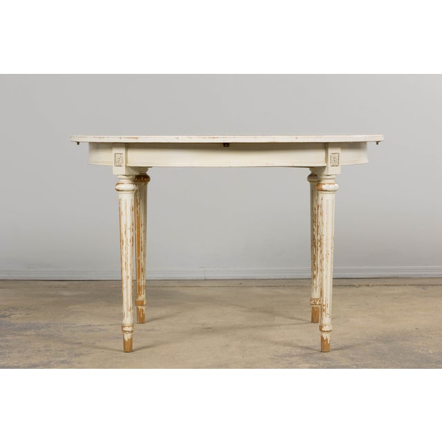 An elegant mid-20th century French Louis XVI style dining table, sourced in Provence. The table rests on four tapered,...