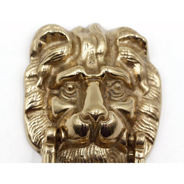 Vintage brass door knocker featuring a lion, often used for its symbolic representation of strength, pride, and...