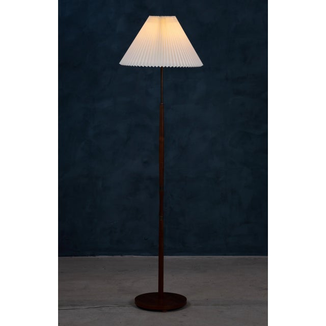 Mid-century floor lamp in rosewood and brass, 1960s, Danish design. The base is made of rosewood with small brass details...