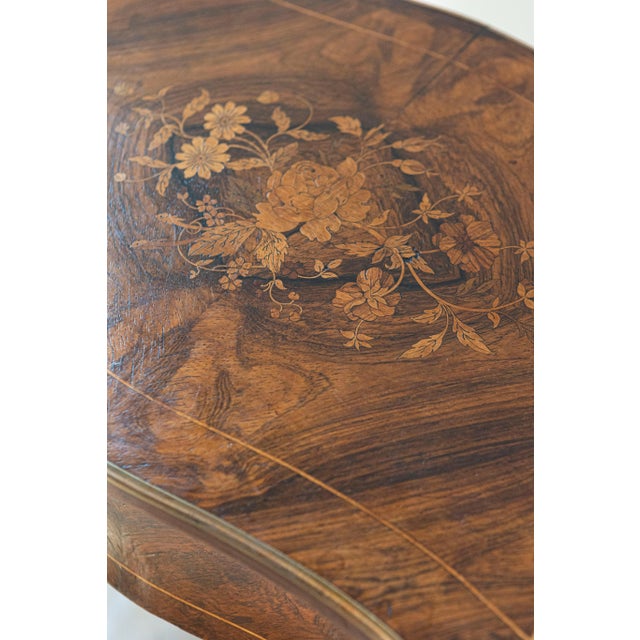 A French Louis XV style marquetry dressing table from the 19th century, with floral motifs and cabriole legs. Born in...
