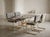 This sophisticated dining set features a stunning combination of brushed brass frames and premium gray velvet upholstery....