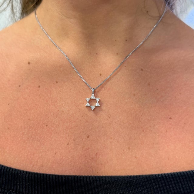 18K white gold necklace sets a Star of David pendant set with six trillion cut natural diamonds totaling 0.56 carats, F-G...