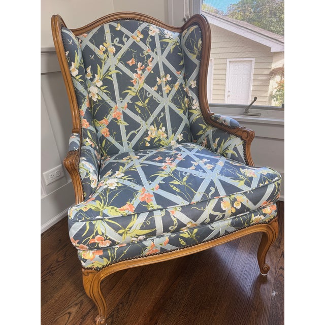 A French Provincial wingback bergère and matching ottoman by Baker Furniture. The ottoman bears Baker's original oval...