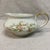 Features a delicate pink and lavender floral garland design with gold trim on the handles and rims. The creamer measures 6...