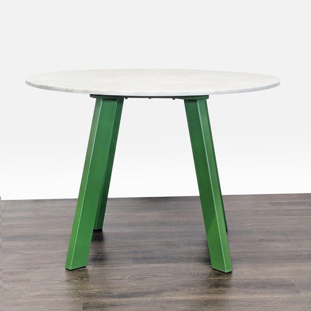 Four powder-coated steel legs provide a sculptural and sturdy base for a honed Carrara marble top. Brand: Blu Dot....
