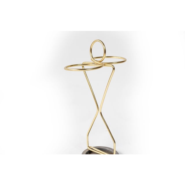 This sculptural umbrella stand is crafted from bent brass wire with a restrained yet expressive form typical of post-war...
