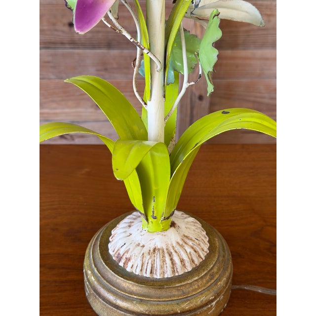 A wonderfully whimsical vintage metal tole table lamp featuring a sculptural arrangement of hand-painted flowers and...
