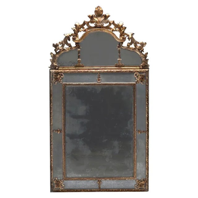 A classic Louis XIV period mirror in the manner of Jean Bérain. Original mercury mirror plates, naturally aged to a soft...