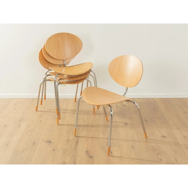 Classic dining chairs, model "Mosquito" by Elmar Flötotto. Stainless steel frame with bent beech plywood seat and...