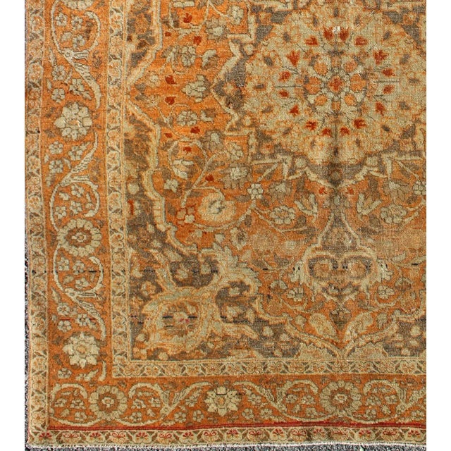 Antique Persian Tabriz Haji Jalili with in Light Orange and light brown This magnificent antique Persian Tabriz carpet...