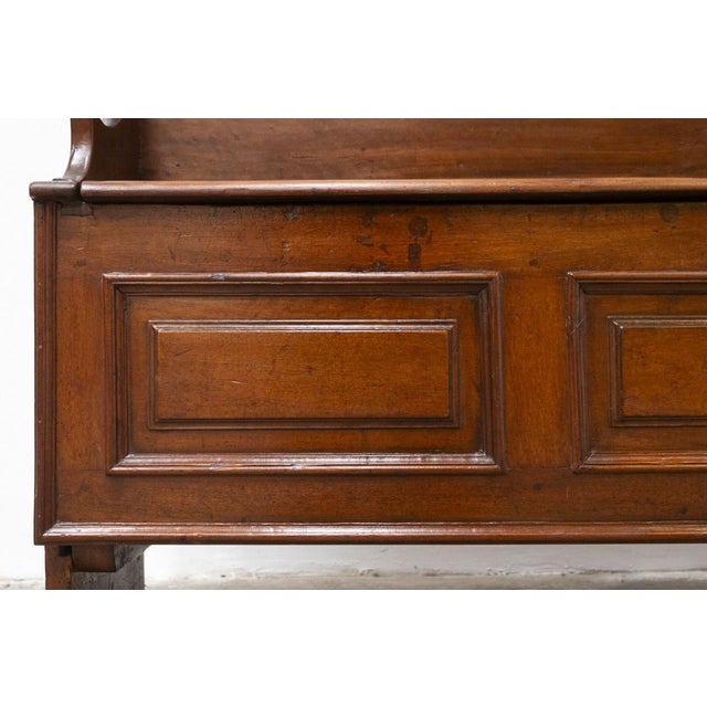 Chest with backrest in solid walnut, 18th century Shaped and carved armrests, opening top divided into two parts,...