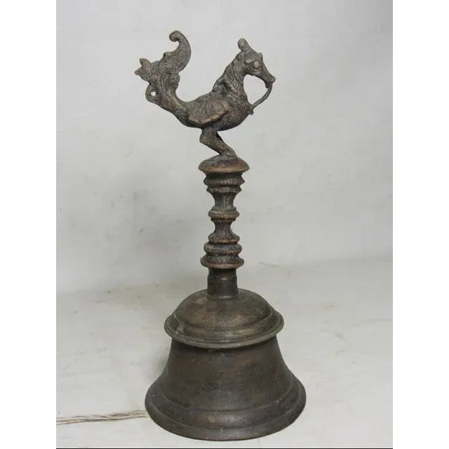Antique Indonesian brass bell, c.1880 The top finial is a mythical bird, below which is a shaped carved handle. The...