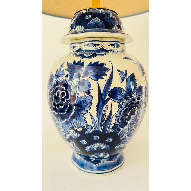 A 20th century table lamp made from a rare Delft ‘De Porceleyne Fles’ lidded vase. Decorated on an off white ground with...