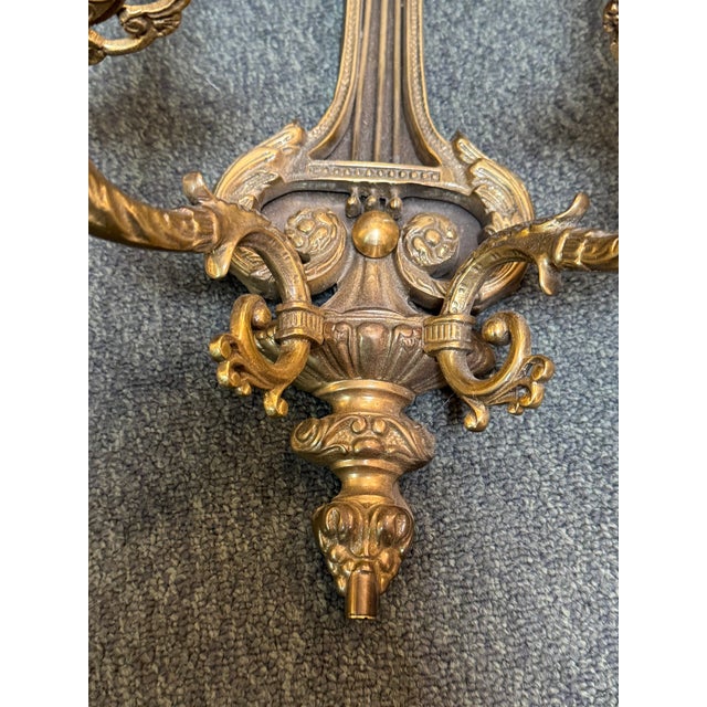 Design Plus Gallery presents a Pair of Gilt Bronze Wall Sconces in the Empire Style of the 1920s. These precious two-light...