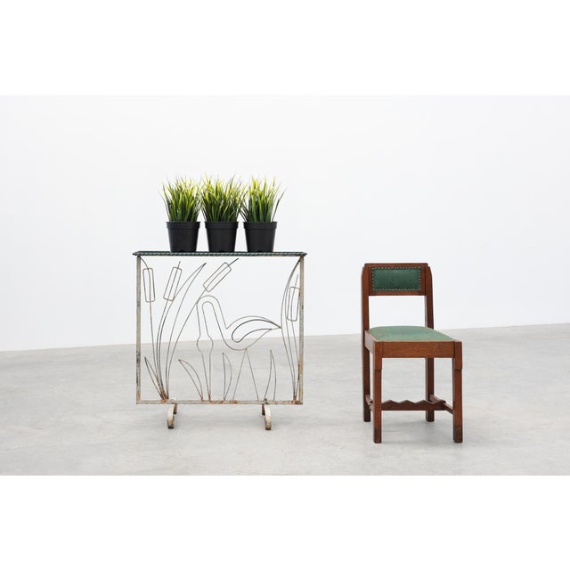 A charming French Art Deco wrought iron plant stand dating from the 1920s, featuring an elegant openwork panel depicting a...