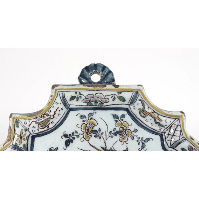 Dutch Delft Chinoiserie Polychrome Plaque, Circa 1730-40 The shaped plaque has a raised molded border decorated with a...