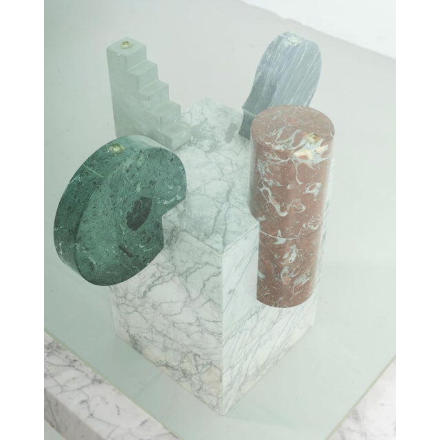 Square Brugiana table with a base in white Carrara marble and geometric elements in arabescato, green Alpi, sandstone, and...