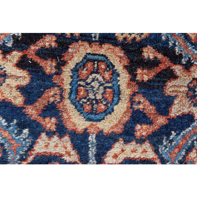 A late 19th century Western Persian Feraghan rug the indigo field with an unusual geometric flowerhead and palmette...