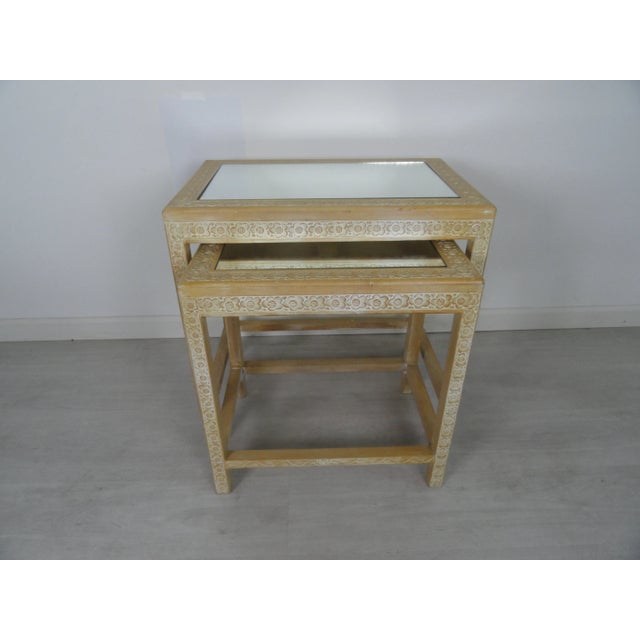 Pair of mid-century Chinese wood carved step tables in a light blonde wood. Carvings on legs and top. Mirrored inserts.