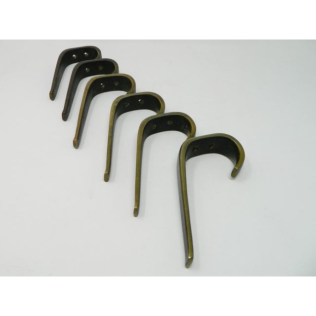 Set of 6 large, high-quality coat hooks from the Hagenauer workshops in Vienna. These hooks are made of cast brass and...