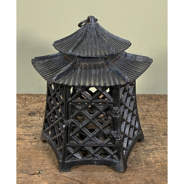 This Japanese cast iron lantern features a pagoda form with a two tiered roof topped with a hanging loop. The hexagonal...