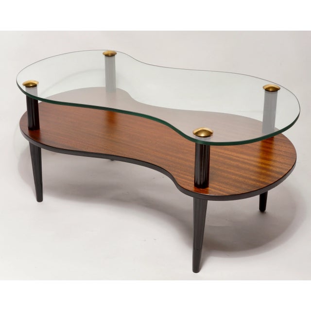 Striking and lovely mid century "cloud" coffee table in the manner of Gilbert Rohde. The table has a solid wood base with...
