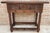 20th century console table with slab top on a frieze with two drawer fronts decorated with carved and incised floral...