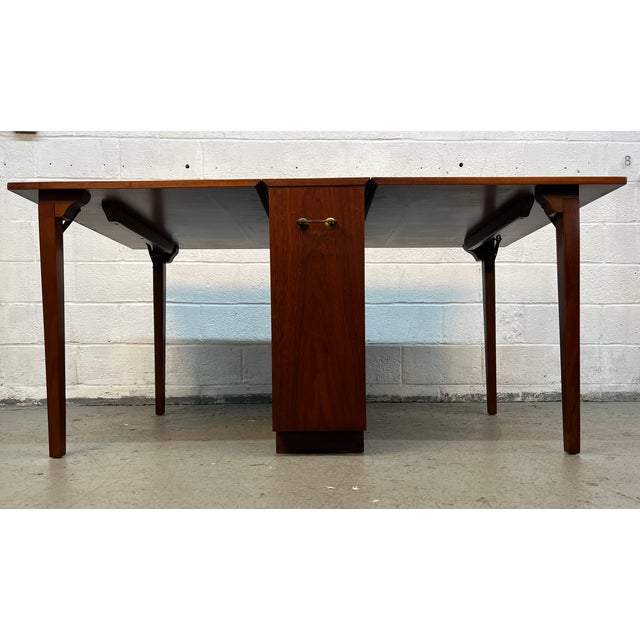 A smart blend of form and function, this Mid-Century Modern Hide-Away Drop Leaf Walnut Dining Table is the perfect...