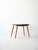Vintage stool with birch wood structure and black imitation leather seat. Characterized by conical legs and the presence...
