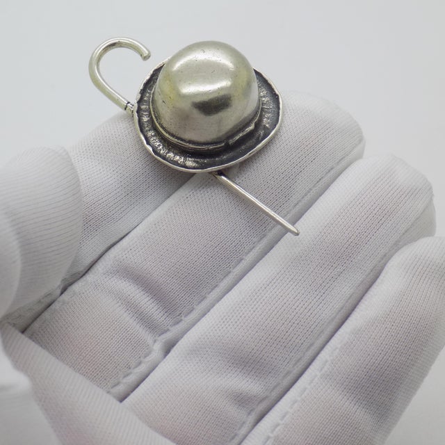 This charming miniature featuring a bowler hat and walking stick was handcrafted in Novara (NO), Italy, during the...