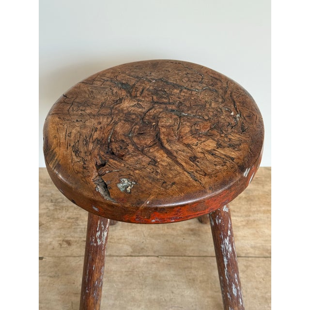 This is an early 20th century primitive round stool set on 4 simple legs. The thick, solid circular wooden top has heavy...