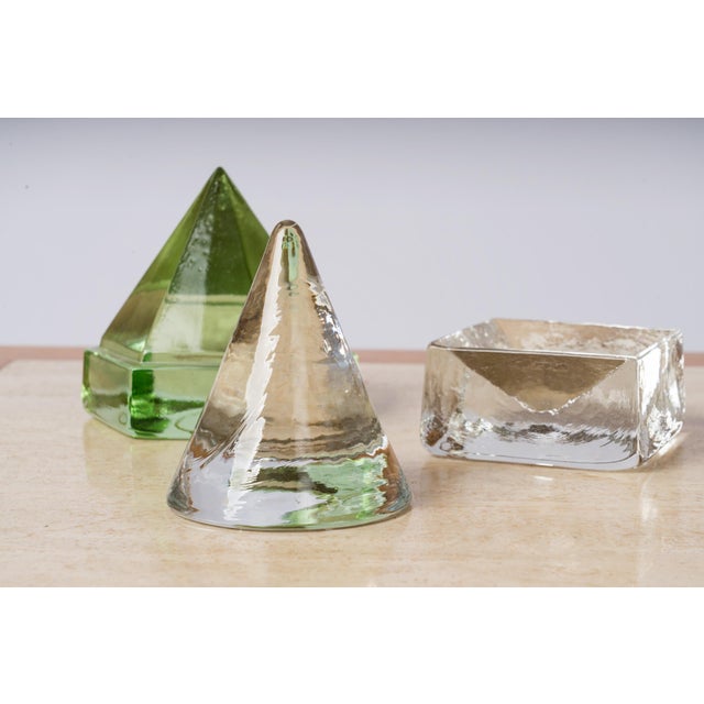 Set of 3 art glass sculptures or paperweights, France 1970s. The set included a faceted green glass pyramid, clear glass...