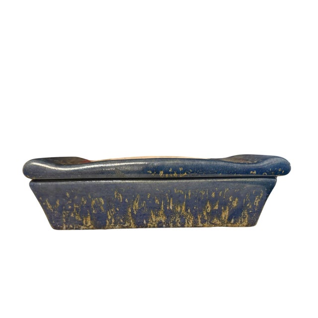 This is a hand made ceramic box with a dark blue glaze speckled with green and light blue. It has a handsome shape with...