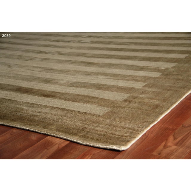 A elegant take on the classic stripe motif. Hand-made using luxurious art silk, the Yunta rug, with its tonal stripes and...