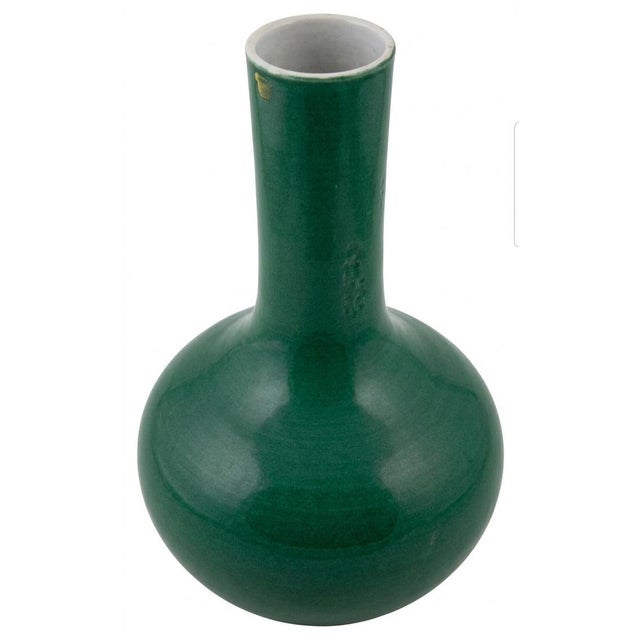 It features a classic bottle vase silhouette, characterized by a bulbous, rounded lower body that smoothly tapers upward...