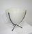 An off-white fiberglass Mid Century bullet planter with black iron tri pod base having rubber tips to the end legs to...