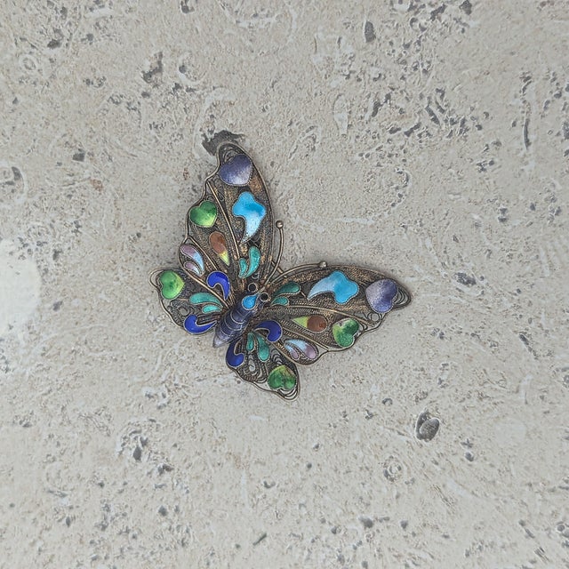 Colorful enamel, a variation of ombred blues, green, and a touch of brown and lime adorn this rare butterfly brooch....