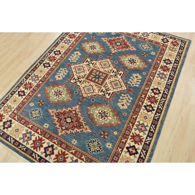 This traditional tribal geometric Caucasian Kazak rug is hand-knotted with an all-wool pile on a cotton foundation. This...