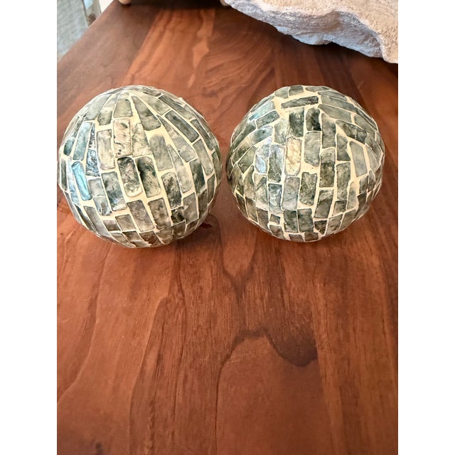 Set of two substantial mosaic decorative orbs featuring hand-laid glass tile in soft coastal tones of greens with white...
