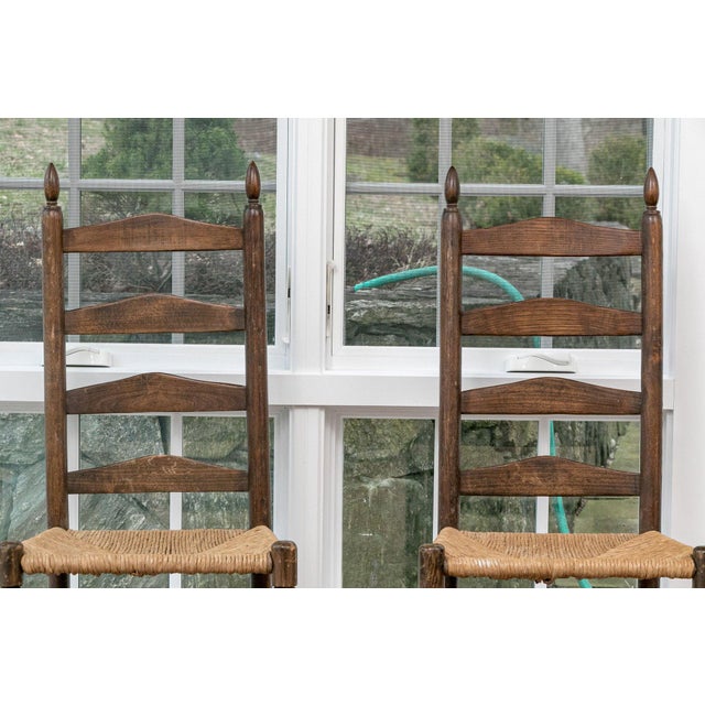 An honest pair of early American (likely classic New England or Mid-Atlantic colonial) dark-stained ladder-back side...