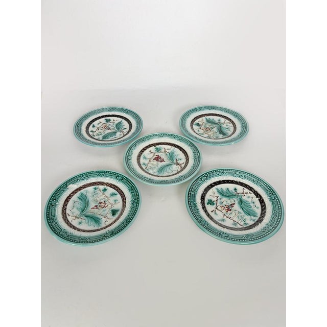 A beautiful set of five antique French majolica plates, featuring an elegant relief design of vine leaves, grape clusters,...