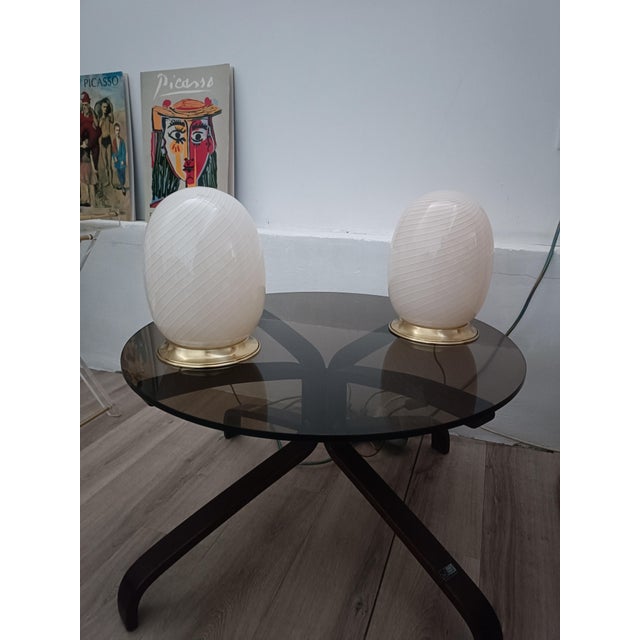 Magnificent pair of Egg table lamps. Italy, 1970s. Brass base. It features a large, egg-shaped tulip shade. Murano glass,...