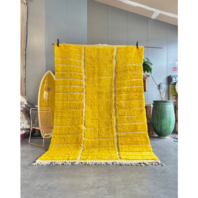 A vibrant Moroccan M’rirt rug distinguished by its luminous golden-yellow colour and minimalist geometric composition. The...
