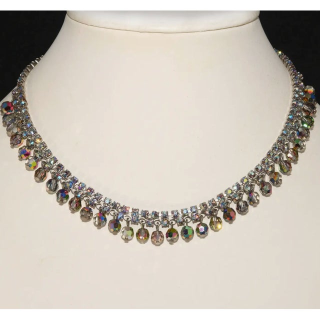 Vintage necklace comprised of blue aurora borealis iridescent rhinestones with dangling faceted glass beads. Metal is...