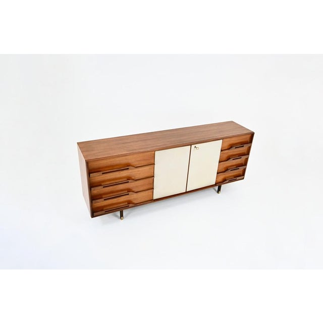 Italian sideboard in wood, brass on the legs and suede on the doors. It includes 8 drawers and 2 doors containing 2...