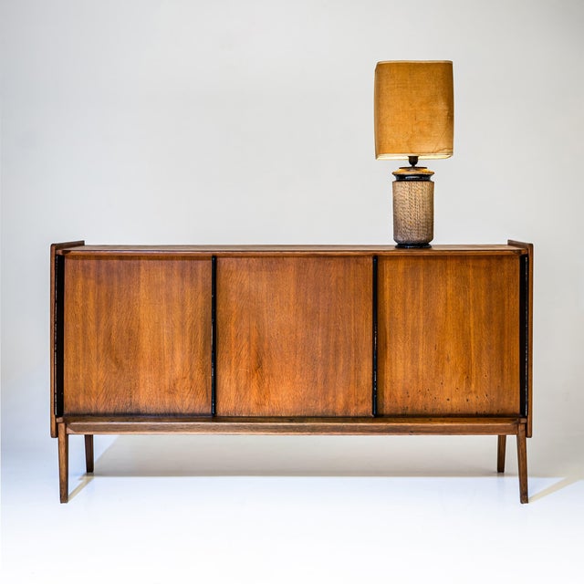 Three-door sideboard from the 1960s, designed by Roger Landault. Made of oak and raised on tapered square legs. The doors...